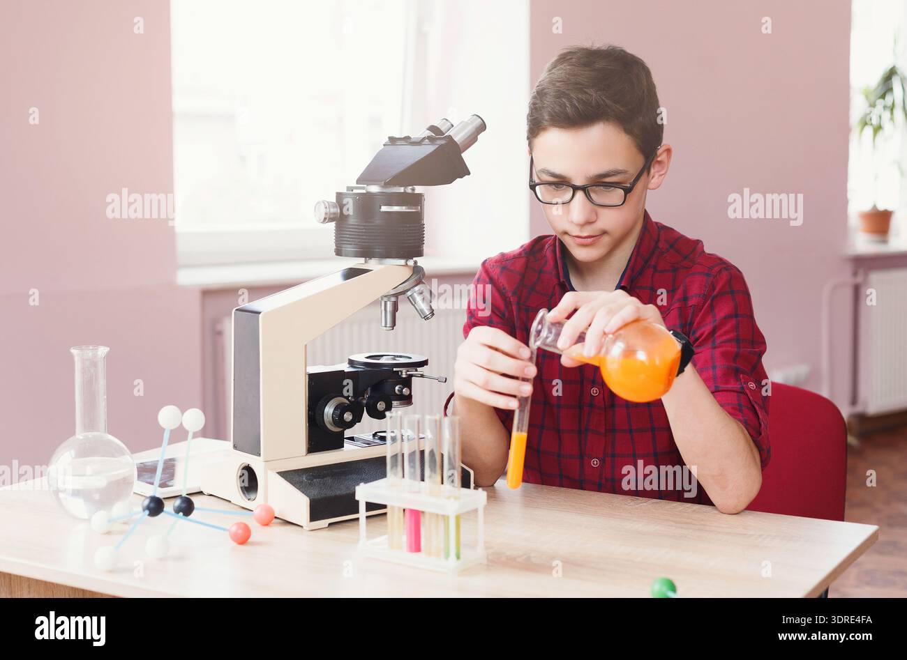 Student Create Experimet Student Conducts an Experiment With a Microscope and Colored Liquids in ...