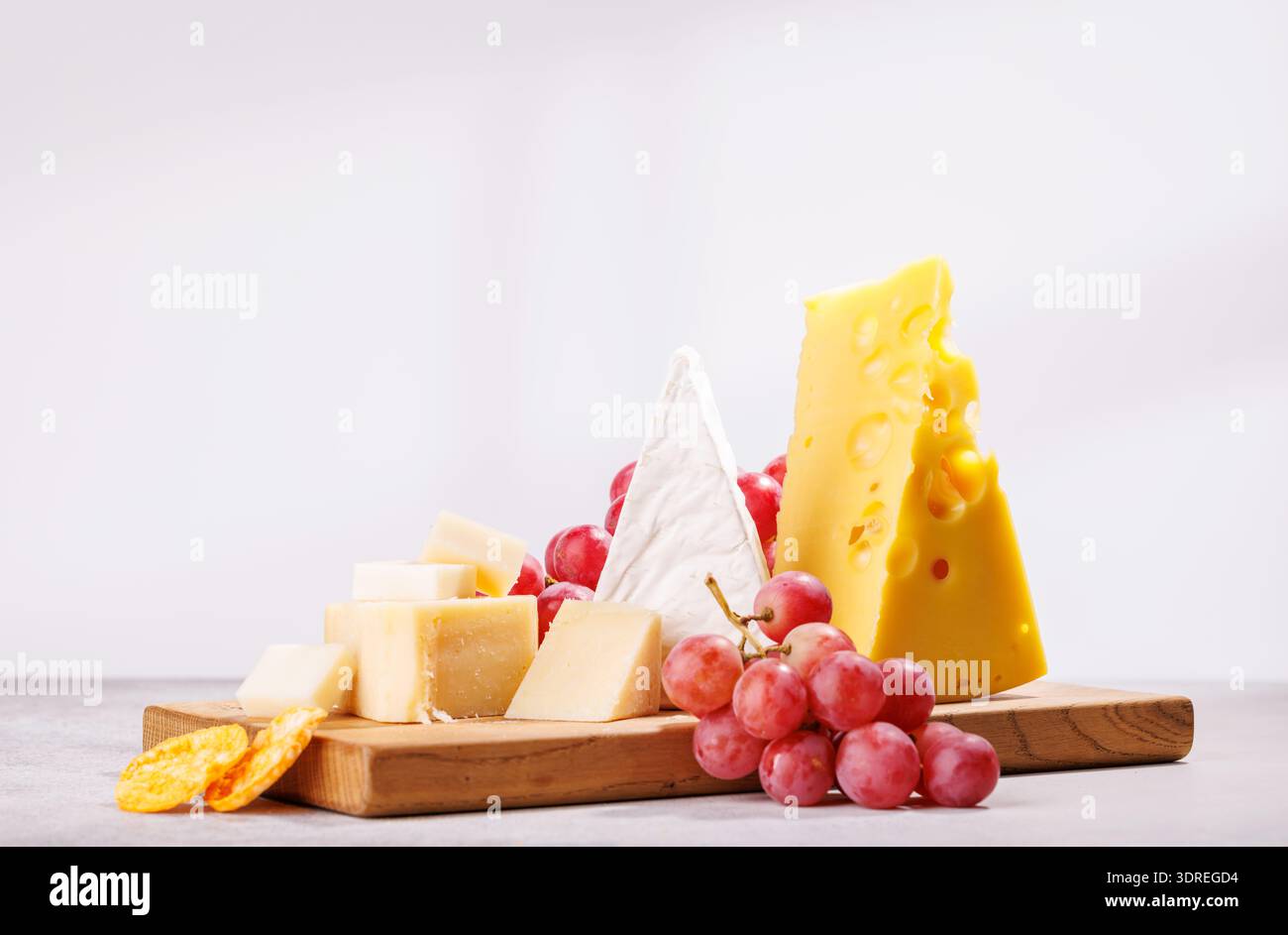 A delectable arrangement of various cheeses, fresh grapes Stock Photo