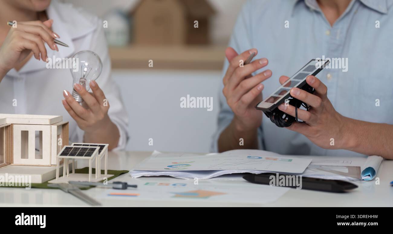 Two people are talking about a project on a table Stock Photo