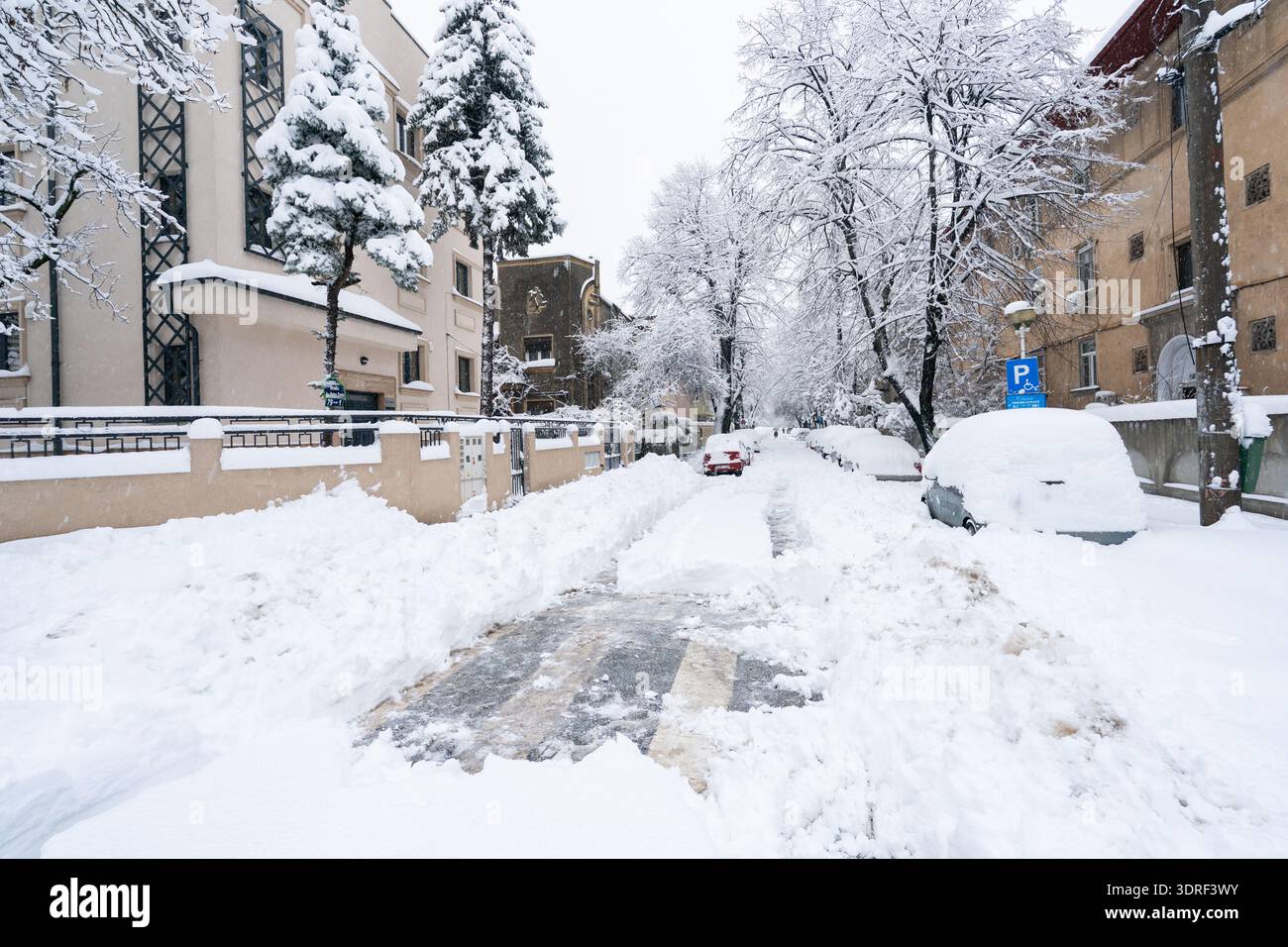 A partially cleared side street in Bucharest reveals uneven snow ...