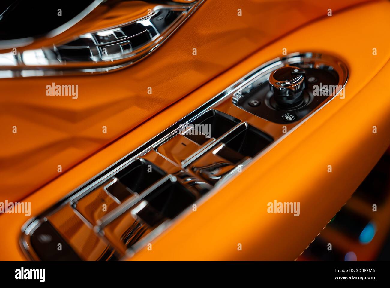 Driver door switch panel with chrome toggles in orange leather Stock Photo