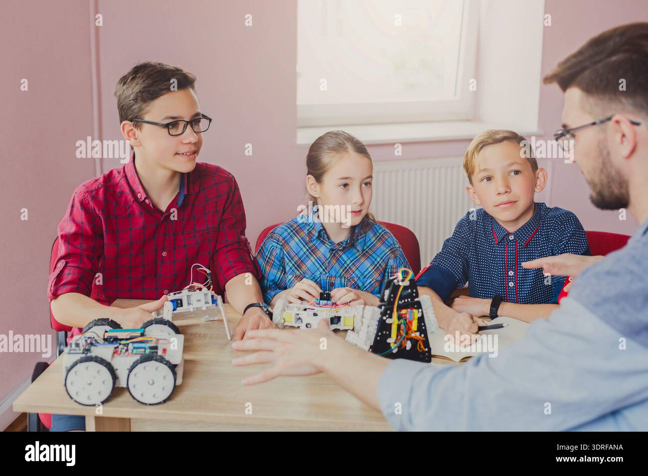 Students Learn About Robotics and Programming in a Classroom Setting Stock Photo