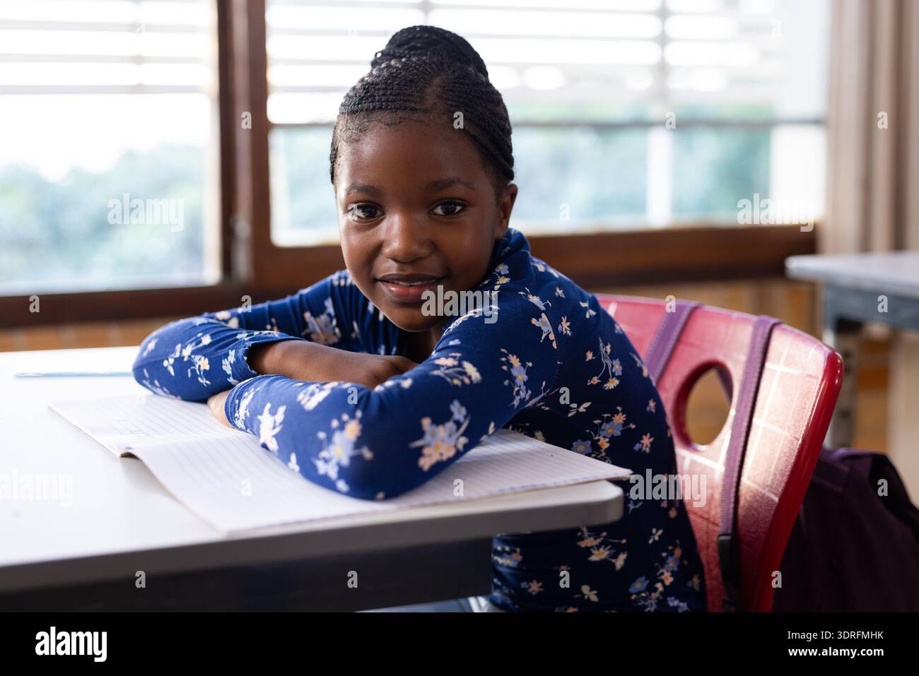 In school, african american girl sitting at desk with open notebook ...
