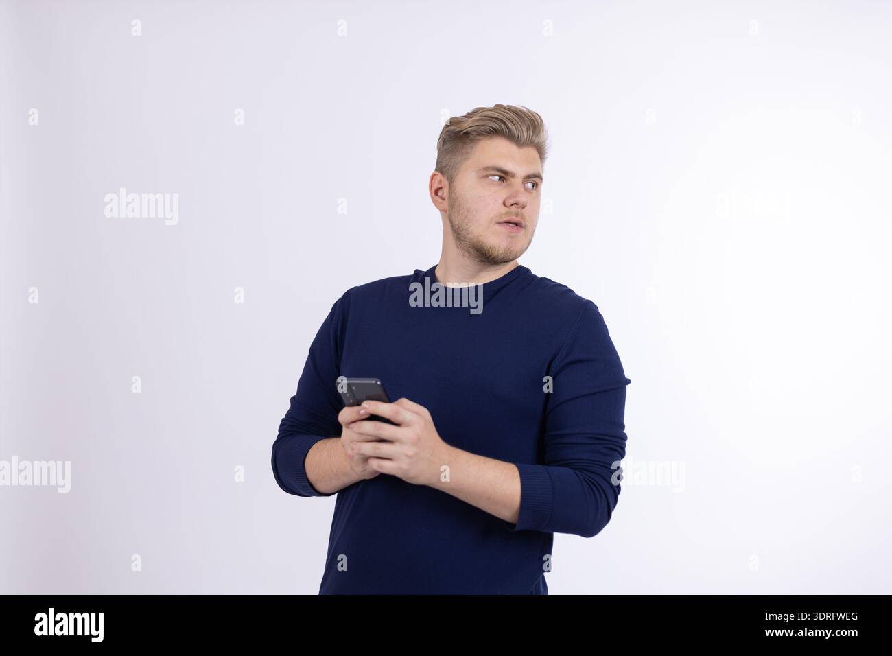 Young man in blue shirt drinking from a cup Stock Photo