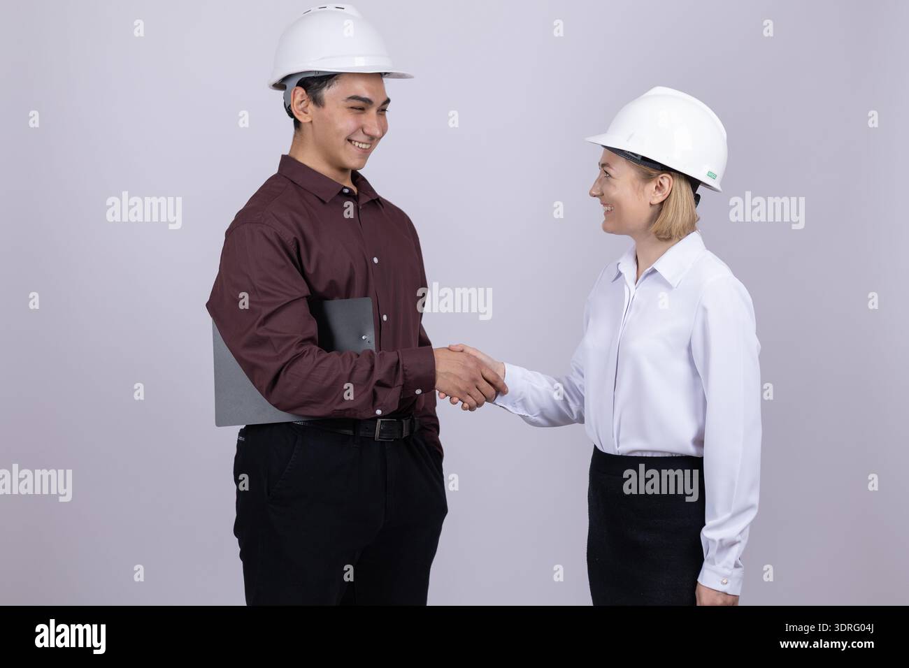 Construction workers shaking hands in a studio Stock Photo
