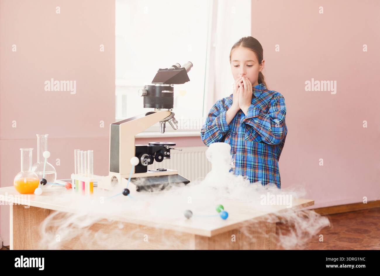 Child Conducts Science Experiment Using Microscope With Fog in a Classroom Setting Stock Photo