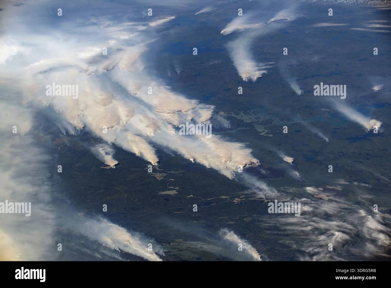 Wildfires burn throughout Canada's central provinces sending smoke drifting into the United States' Great Lakes and Northeast regions impacting air quality. The International Space Station was orbiting 262 miles above Canada at the time of this photograph.  A photograph taken from the International Space Station on 3 August 2025  An optimised version of an original NASA image: Credit NASA/NAyersWildfires Stock Photo