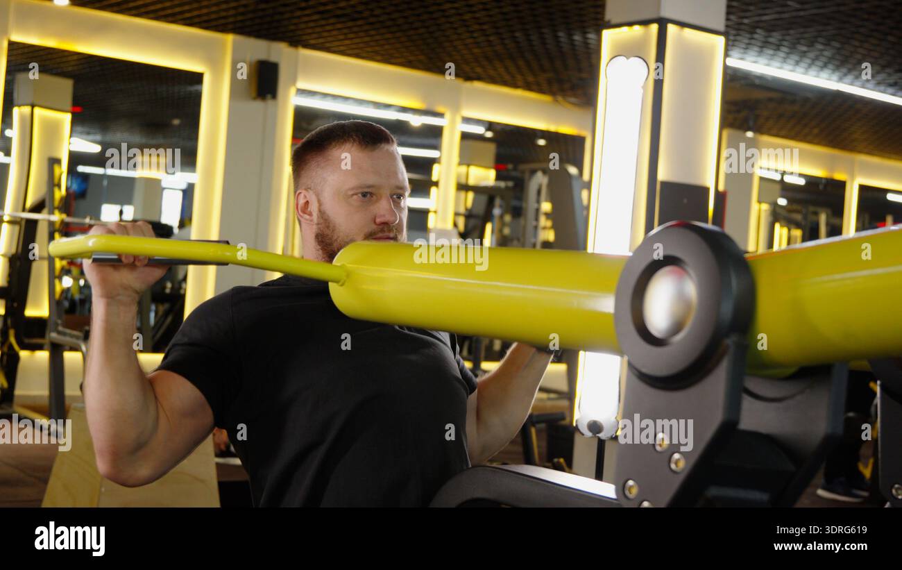 Man doing chest press on machine in gym Stock Photo