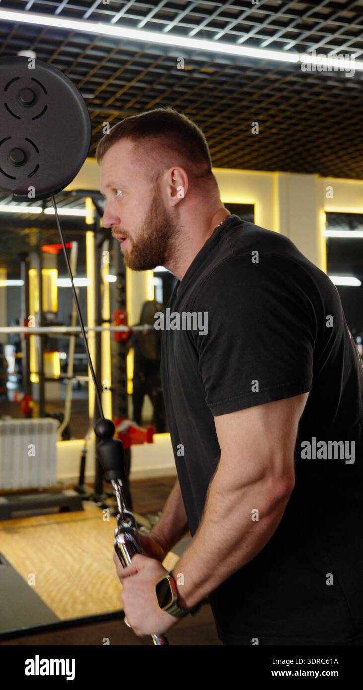 Bodybuilder training triceps on cable machine Stock Photo