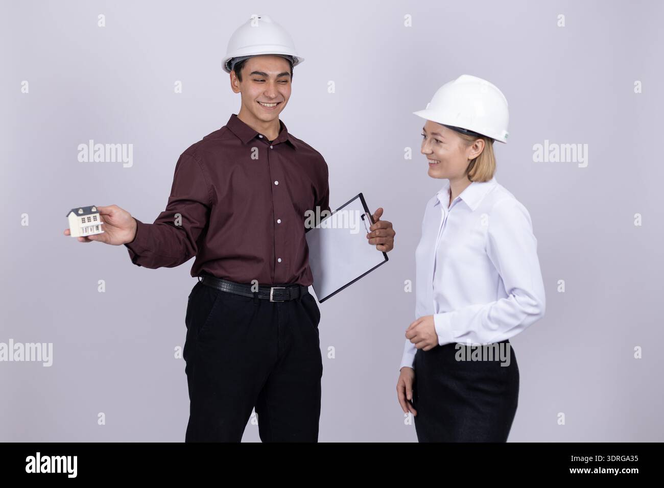 Engineers in safety gear discussing project details Stock Photo