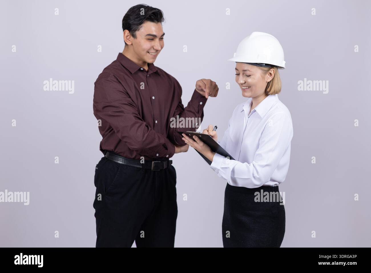 Team of construction workers shaking hands in studio Stock Photo