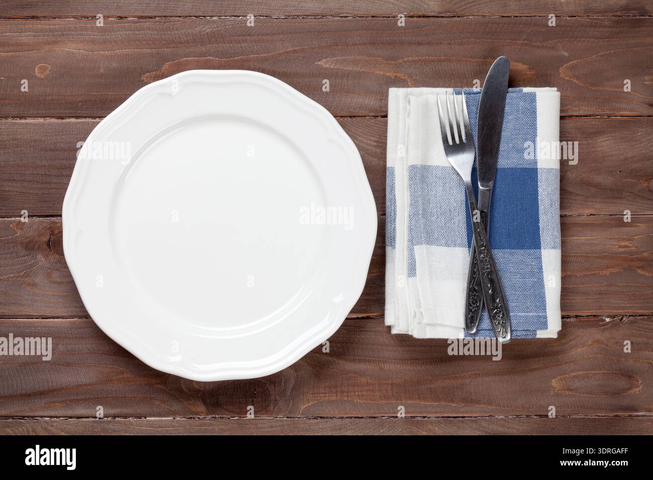 Empty plate and silverware over wooden table Stock Photo