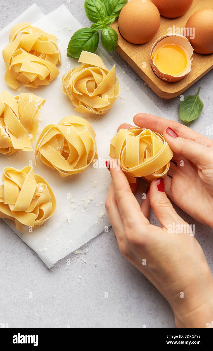 Chef preparing homemade tagliatelle pasta with eggs and basil Stock Photo