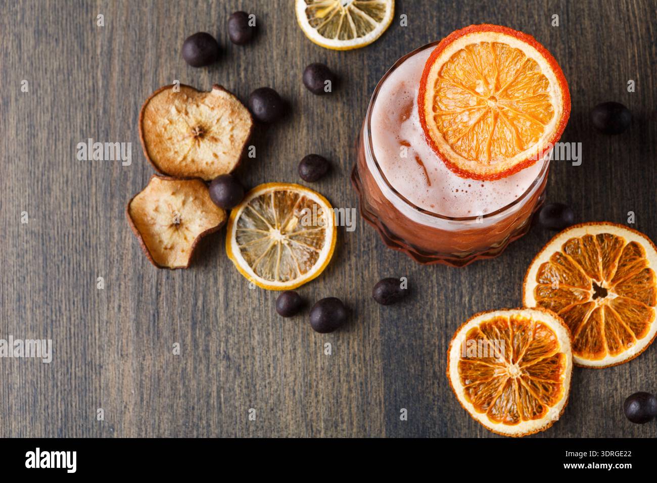 Drink With Dried Citrus and Chocolate Balls on Wooden Table in Bright Setting Stock Photo