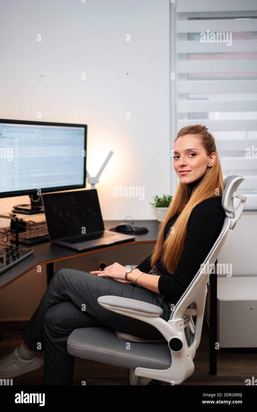 Young woman working from home office smiling at camera Stock Photo