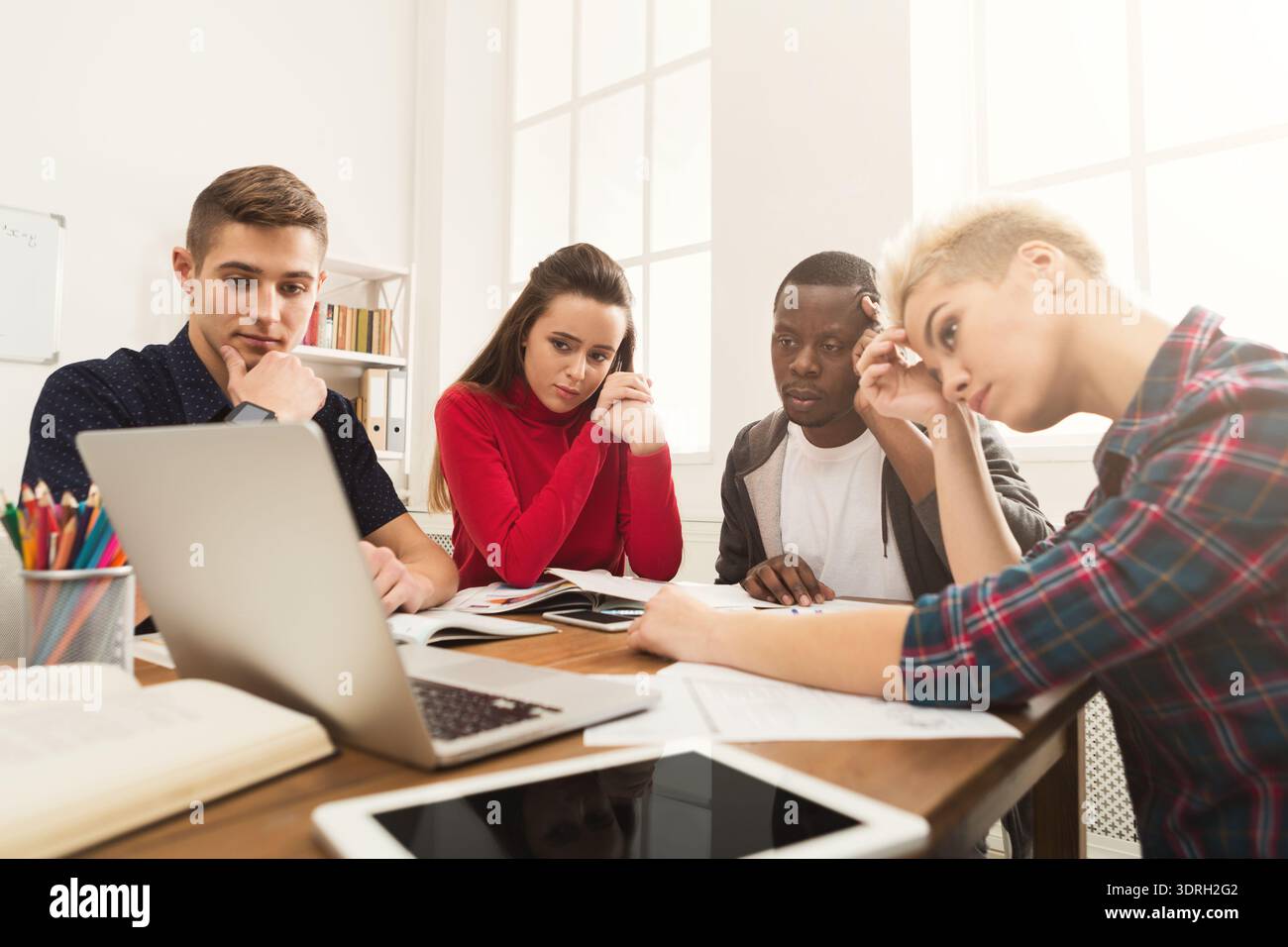 Group of Students Focused on Their Project While Working on a Laptop at a Table Stock Photo