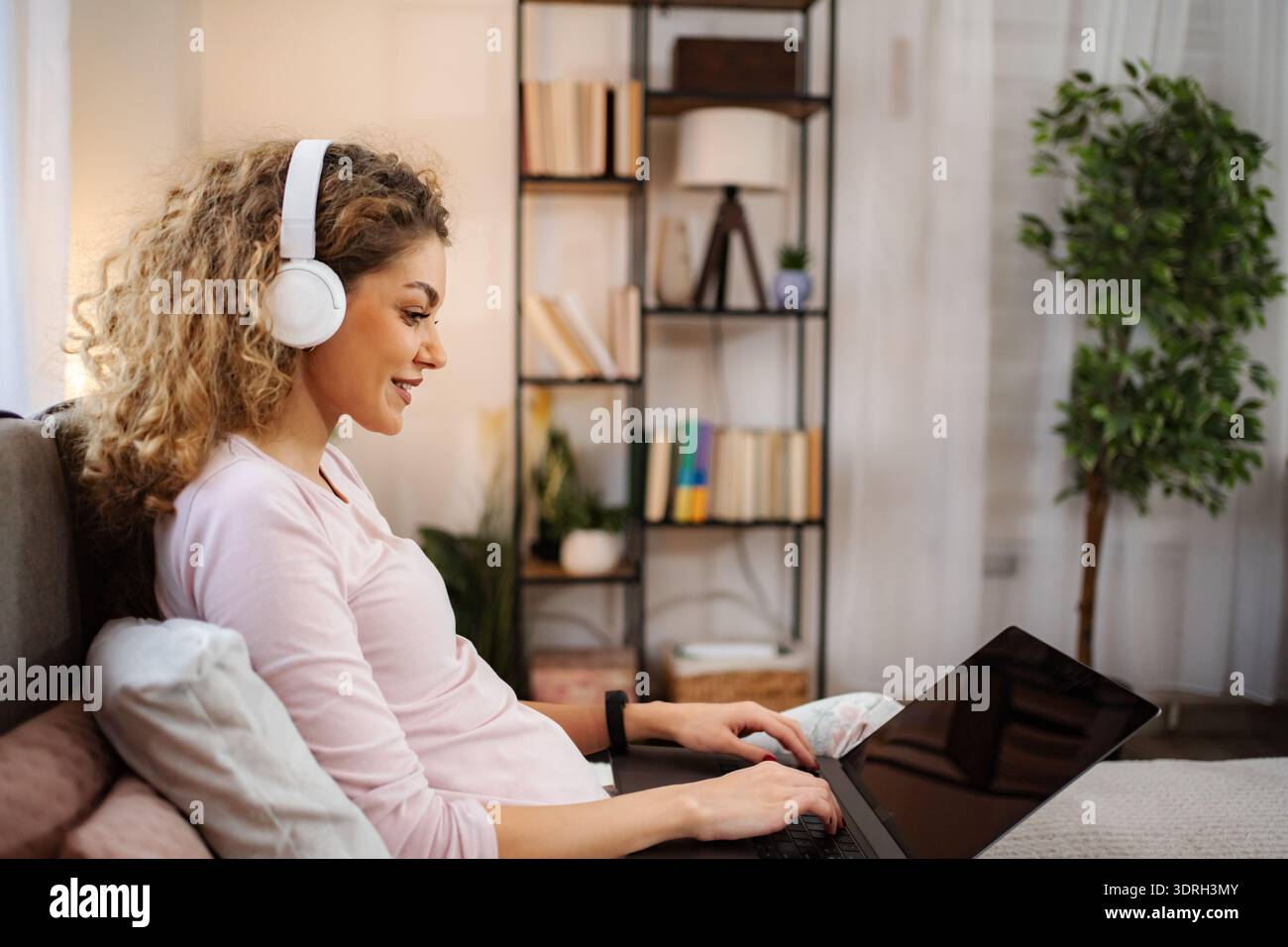Woman enjoying remote work watching something on laptop Stock Photo