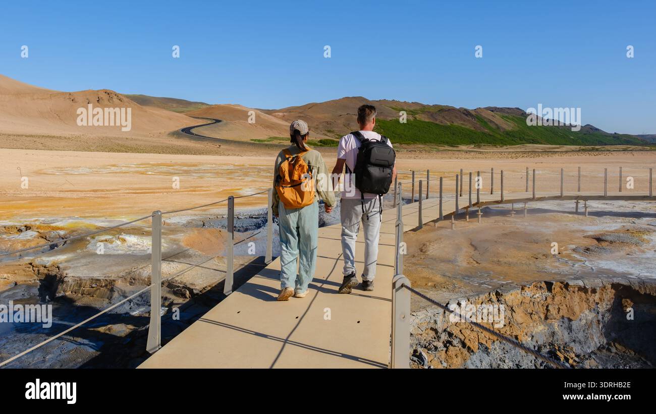 Exploring the geothermal wonders of Iceland with friends on a sunny day in nature Stock Photo