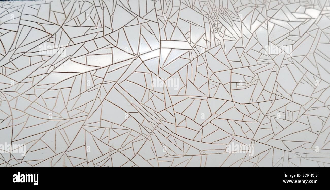 Cracked and peeling white plastic surface with intricate fracture patterns Stock Photo