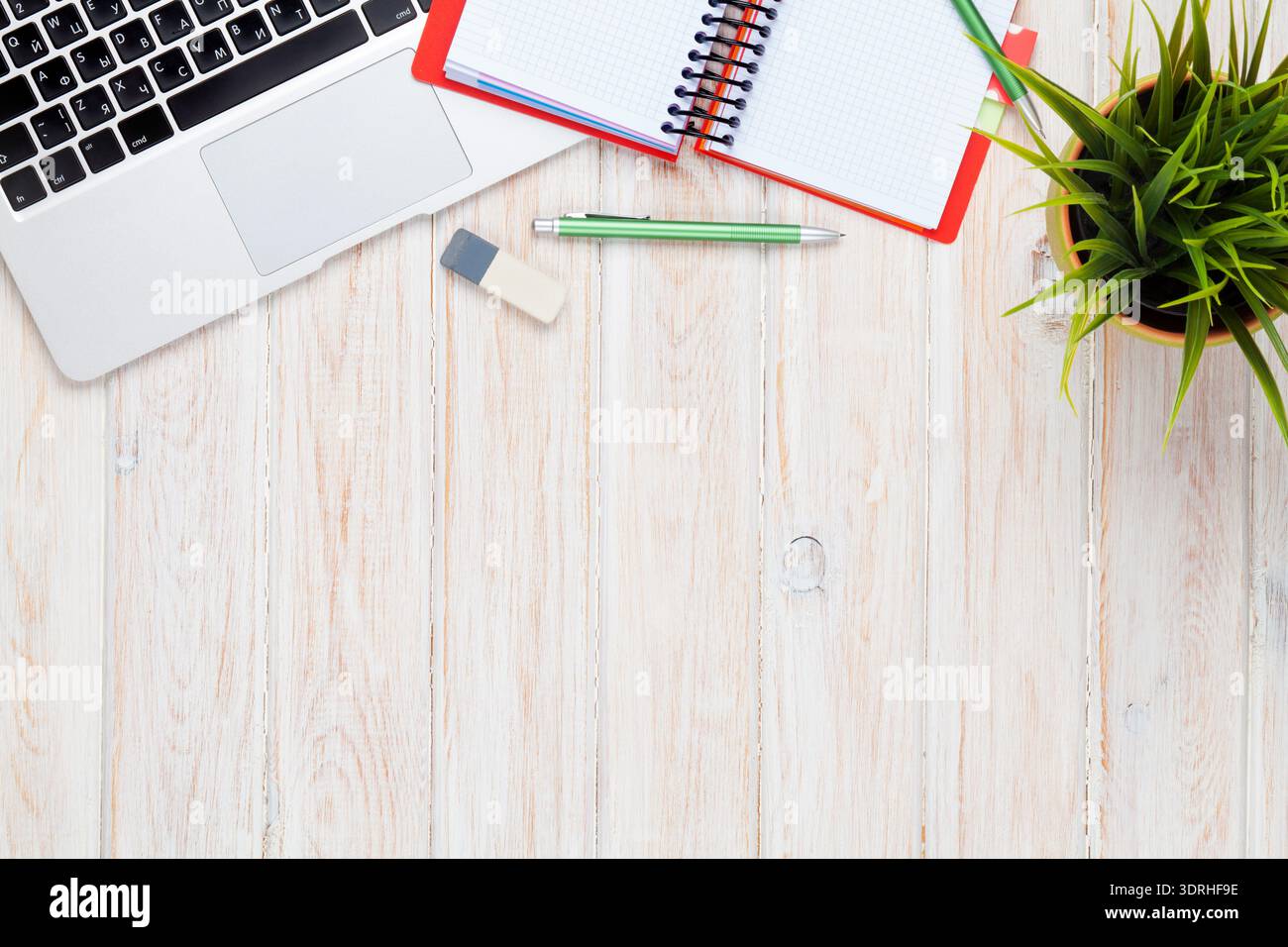 Office desk table with computer, supplies and flower Stock Photo