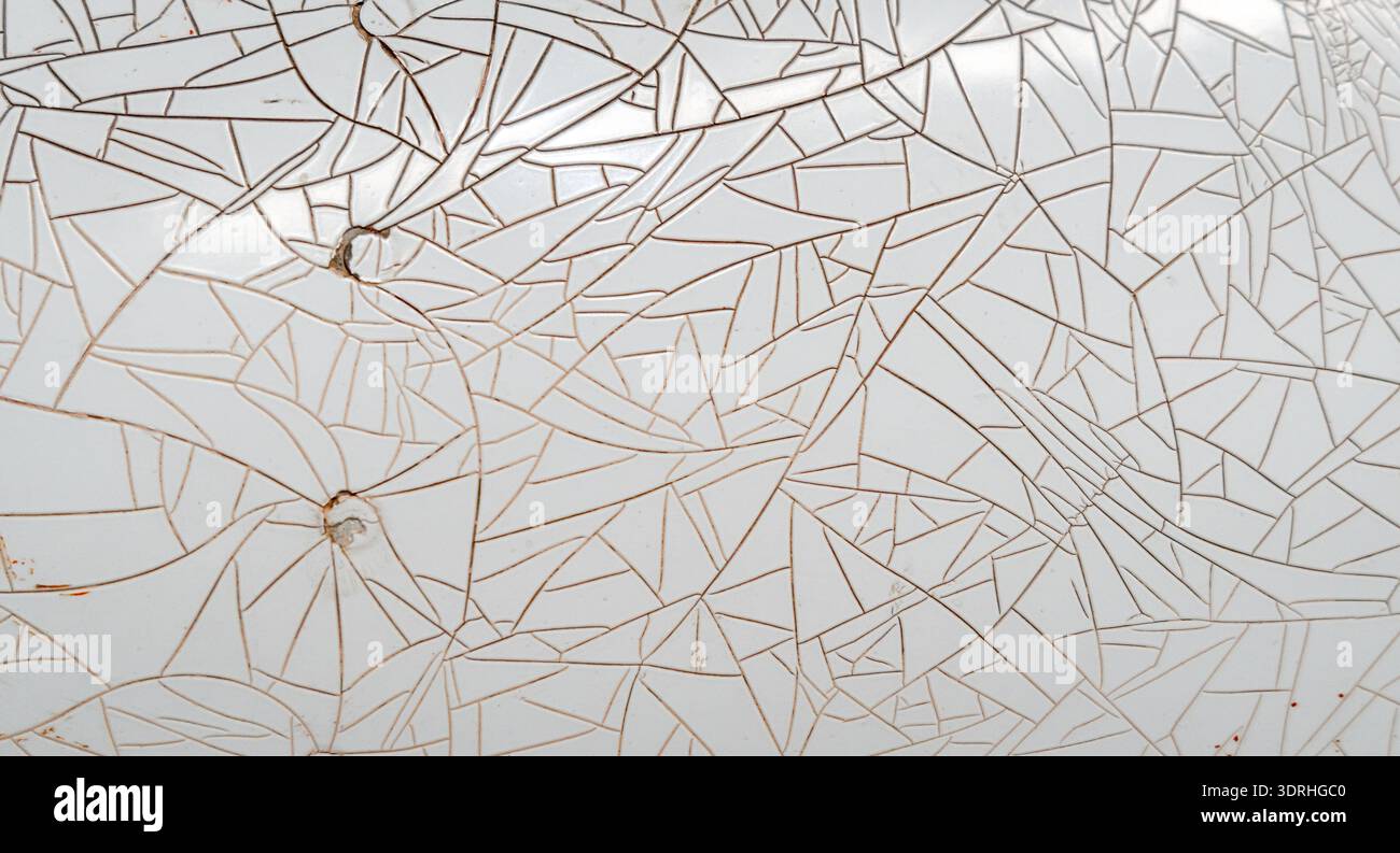 Cracked and peeling white plastic surface with intricate fracture patterns Stock Photo