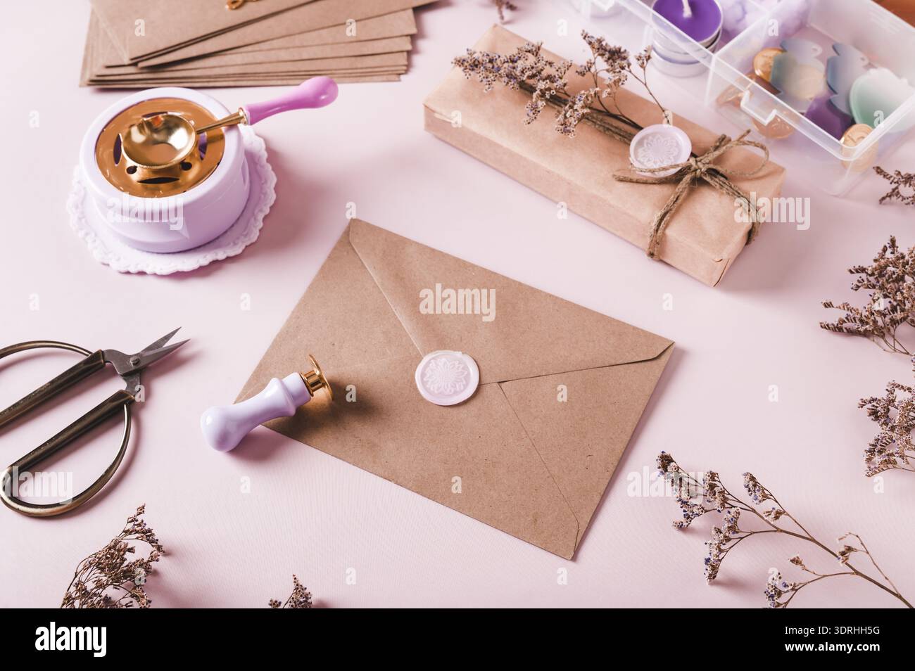 Craft envelope with wax seal and crafting items on pink Stock Photo