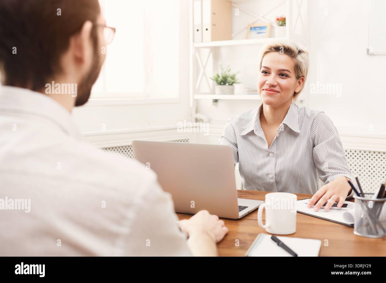 Discussion Between Two Colleagues in a Modern Office Setting During Daytime Hours Stock Photo