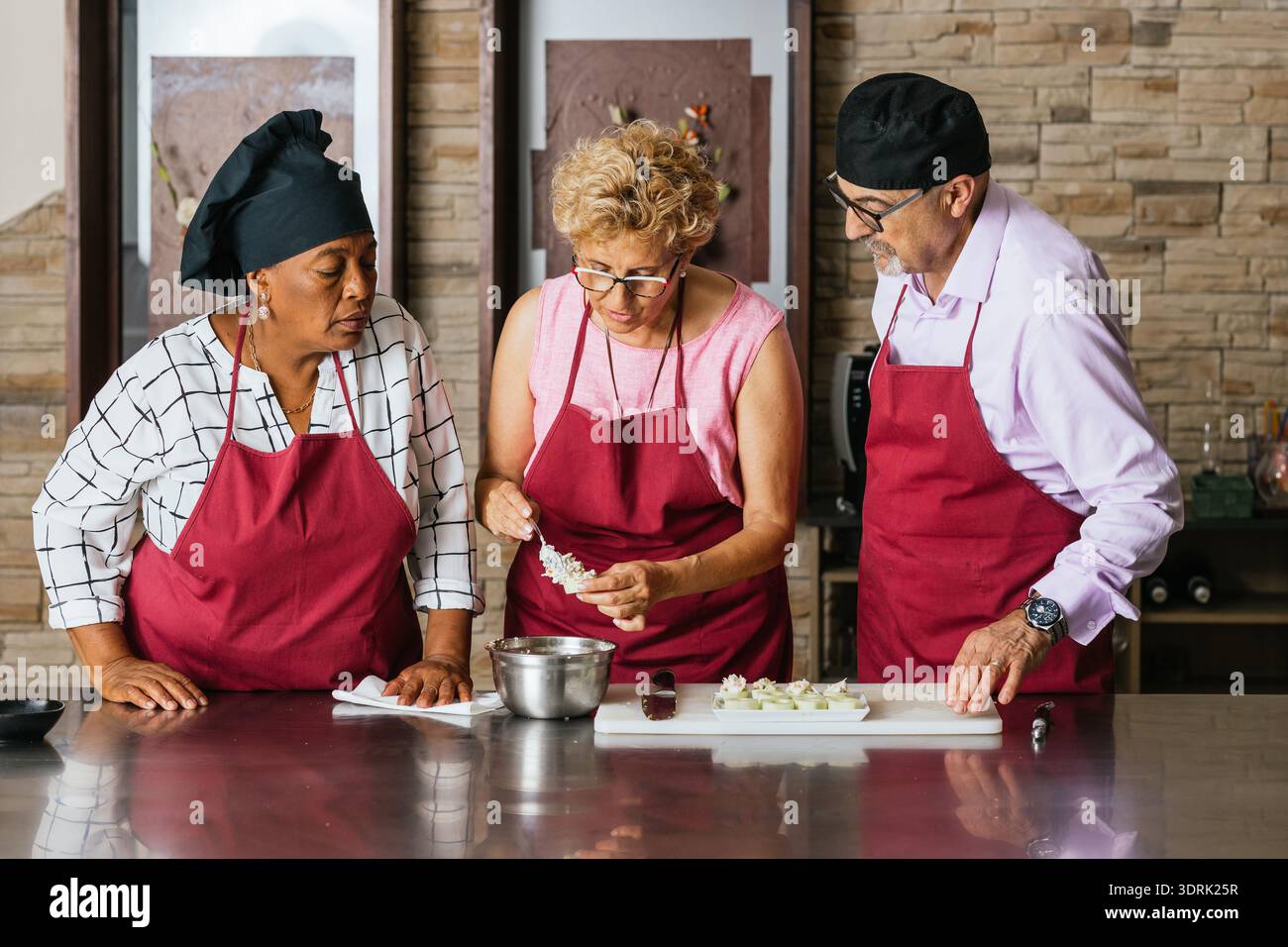 Chefs preparing ingredients during cooking course in restaurant kitchen Stock Photo