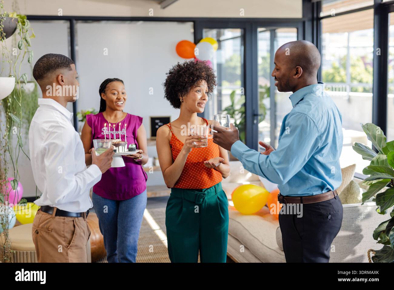 At office celebration, African American colleagues having drinks and talking together. teamwork, collaboration, diversity, workp Stock Photo