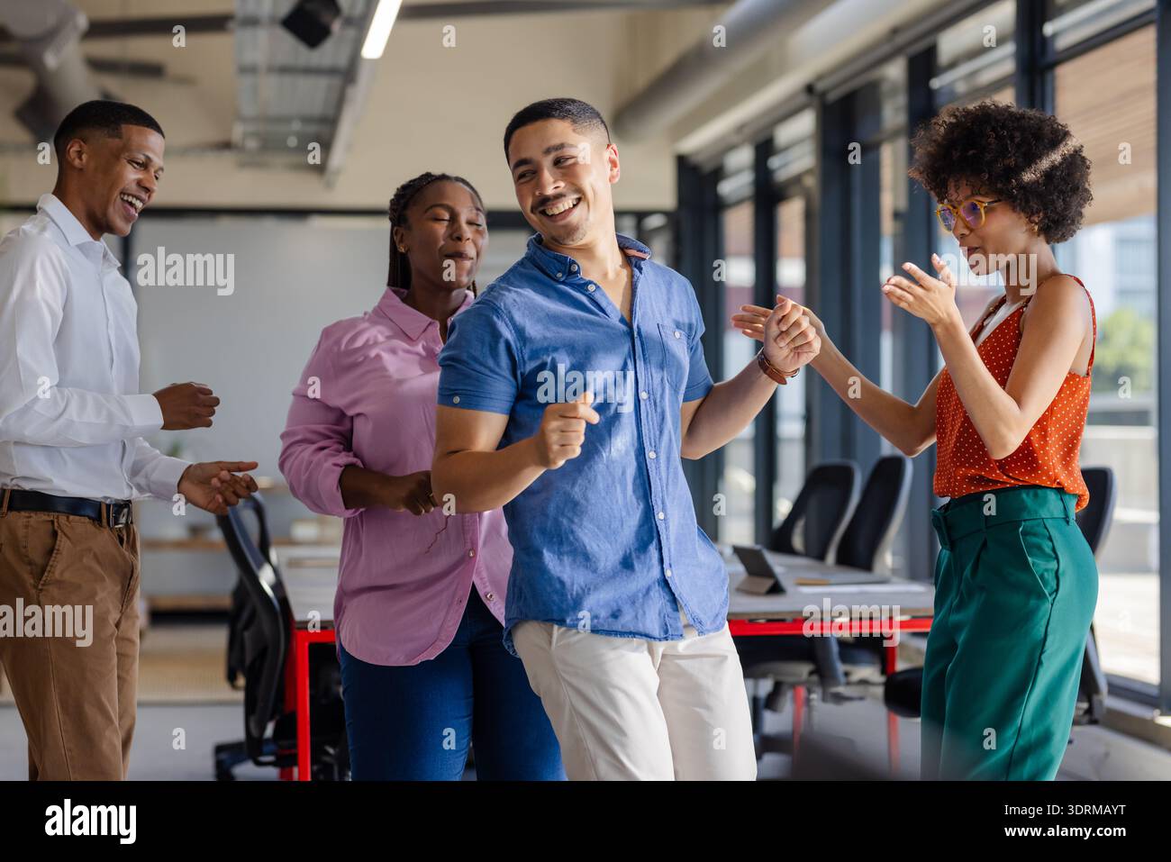 Dancing and laughing, colleagues enjoying lively break together in office. Teamwork, collaboration, workplace, cheerful, joyful, Stock Photo