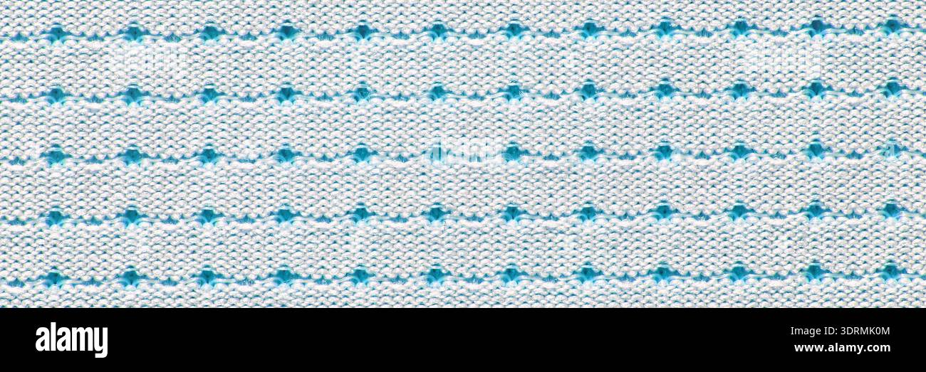 Red and white dotted pattern on knitted fabric background with repeating Stock Photo