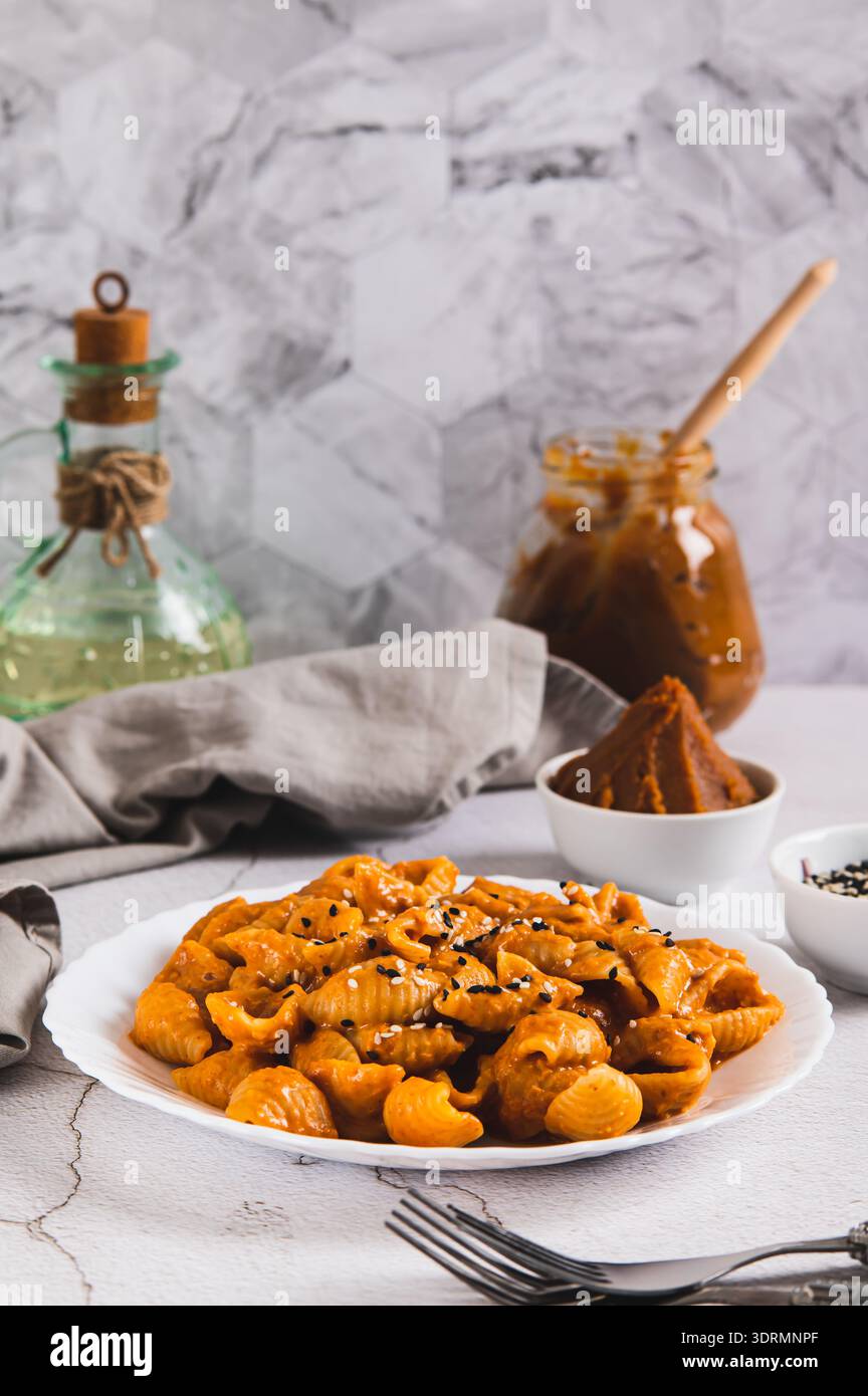 Spicy miso pasta shells on a plate on the table vertical view Stock Photo