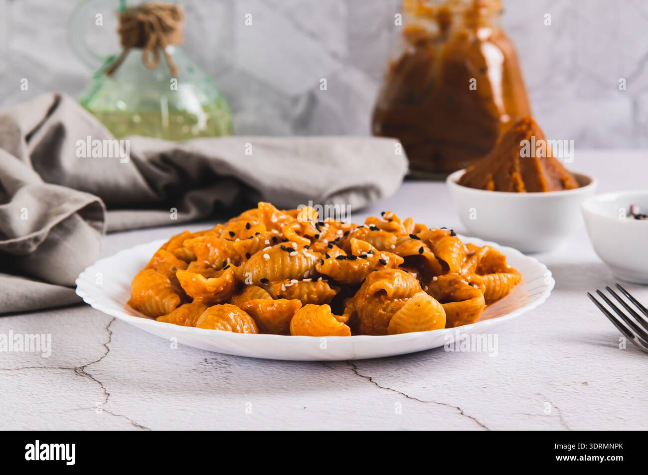 Spicy miso pasta shells on a plate on the table Stock Photo