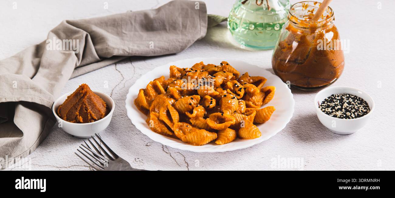 Spicy miso pasta shells on a plate on the table web banner Stock Photo
