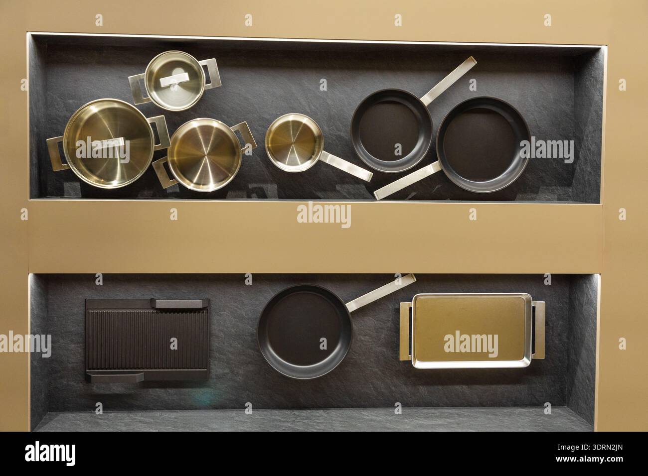 Modern kitchen cookware collection displayed on sleek shelving unit Stock Photo