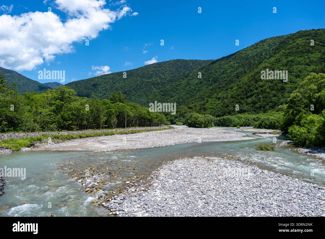 The Azusa River winds through lush forest beneath snow-dusted peaks on ...