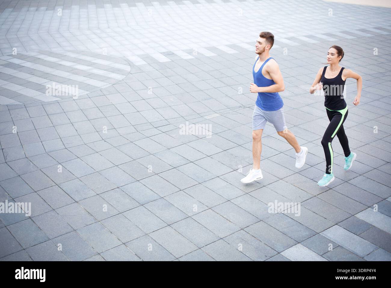 Running Together on a City Pavement in the Early Morning Light Stock Photo