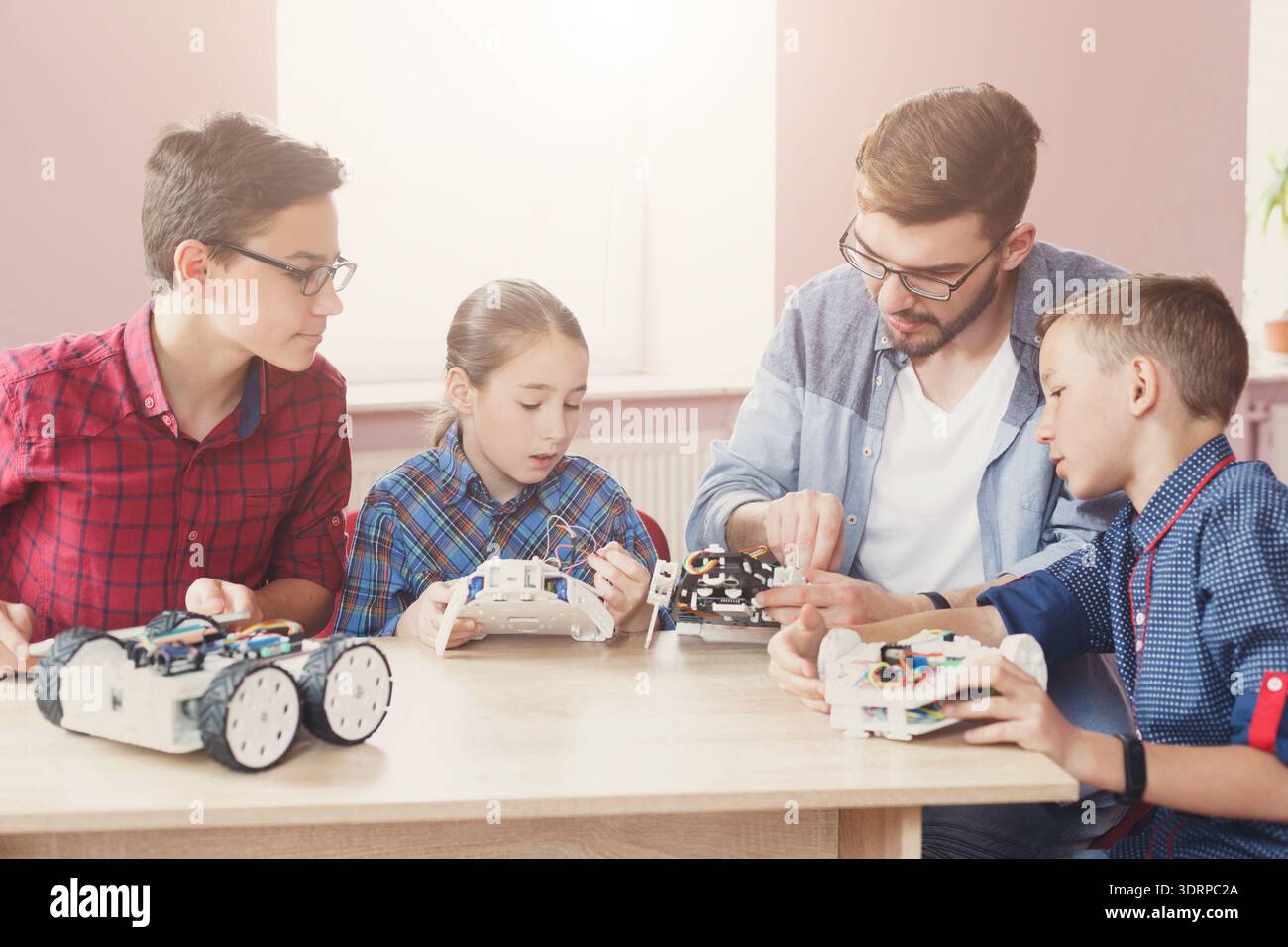 Students and Teacher Work Together on Robotics Projects in a Classroom Setting Stock Photo