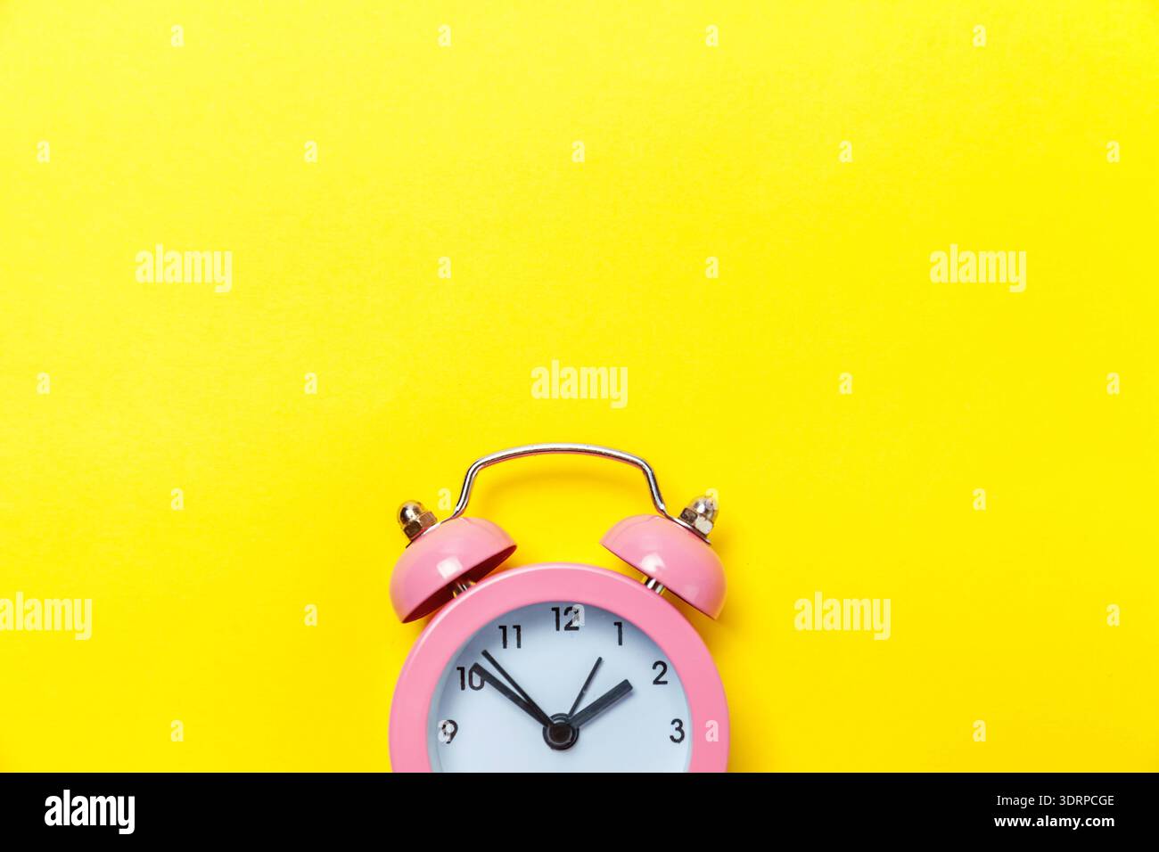 Vintage alarm clock Isolated on yellow background Stock Photo