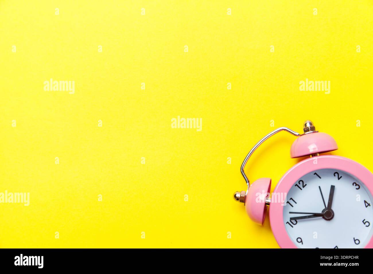 Vintage alarm clock Isolated on yellow background Stock Photo