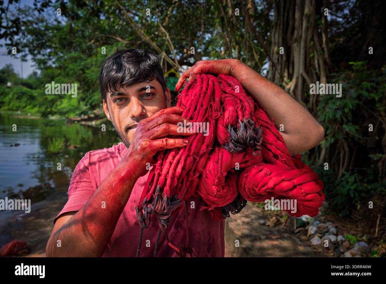 Man carrying freshly washed treads, Odisha, India Stock Photo