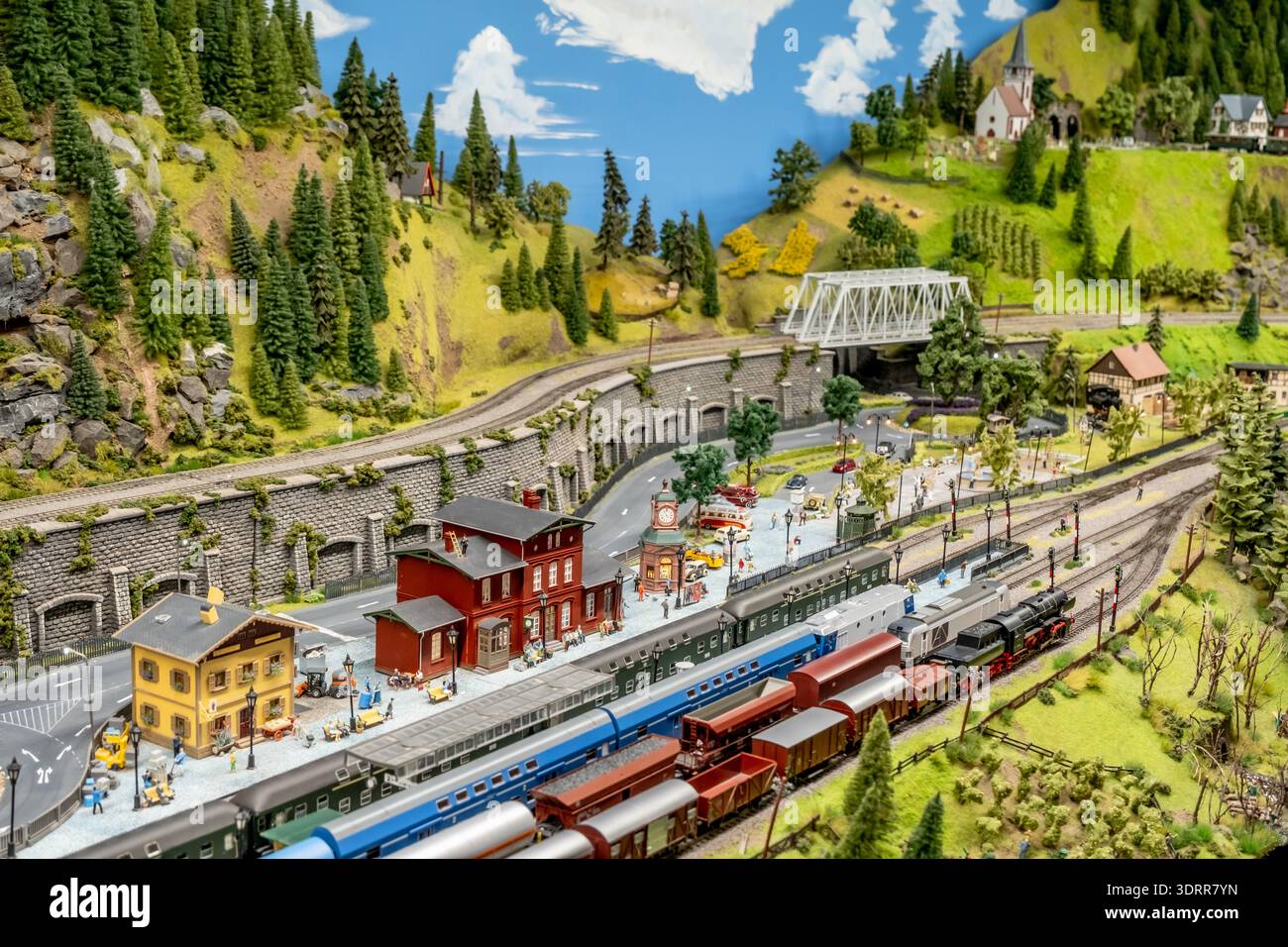 a detailed and colorful model train layout depicting a small railway ...