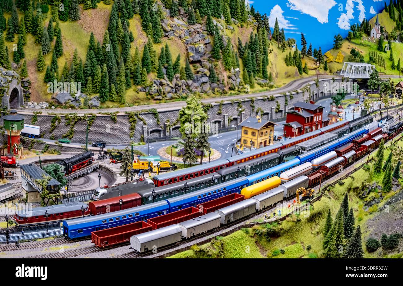 a detailed, colorful model train layout depicting a small railway yard ...