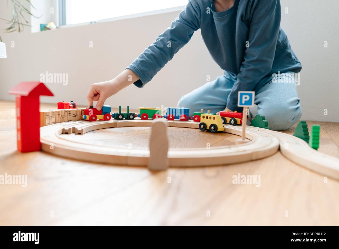 Adult helping child build wooden train track. Montessori-inspired ...
