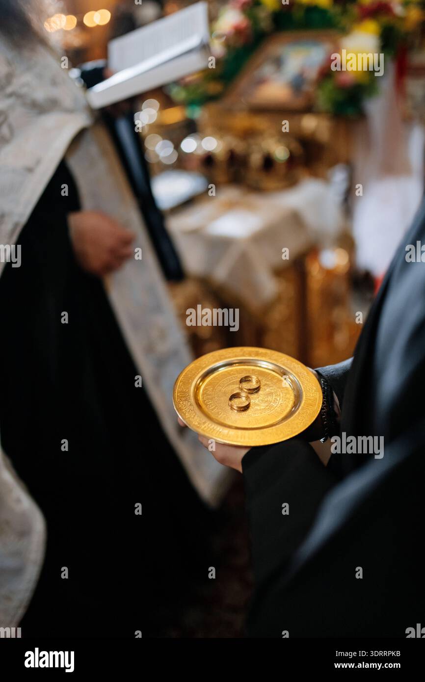 Wedding rings on golden plate during Orthodox church marriage ceremony ...