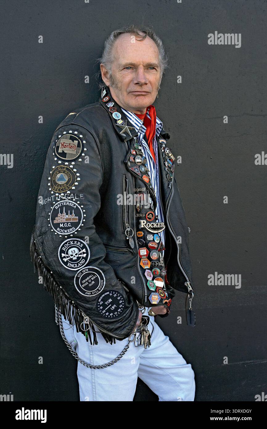 Older rocker wearing a leather jacket covered in studs, pins, and ...