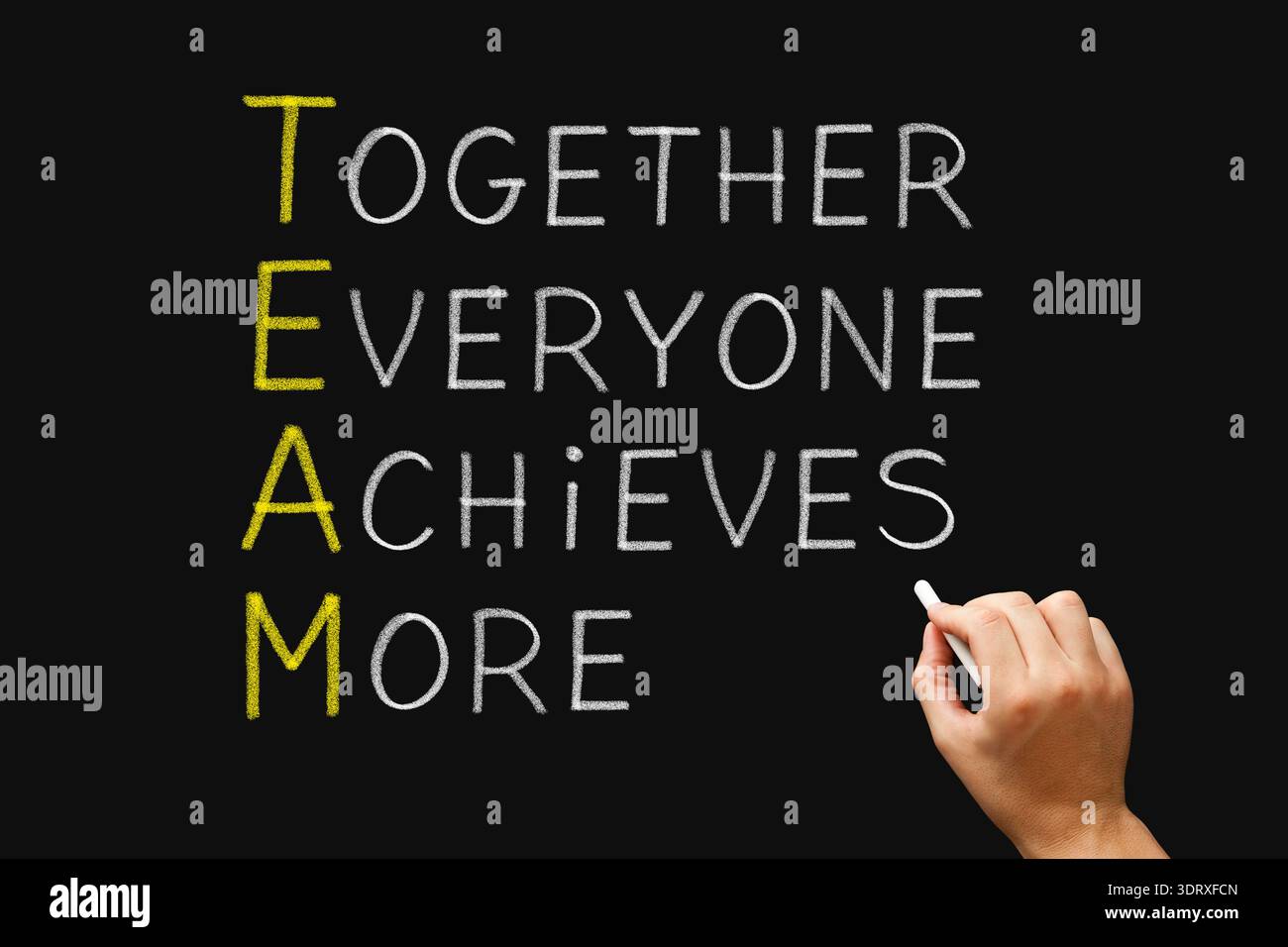 Hand writing TEAM Together Everyone Achieves More on chalkboard ...