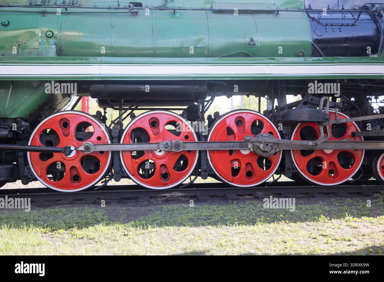 Four red train wheels under a green steam locomotive; coupled wheels ...