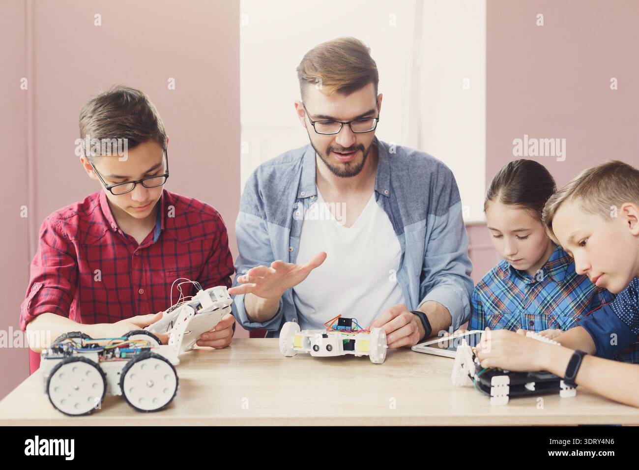 Group of Children Learning About Robotics and Programming in a Classroom Stock Photo