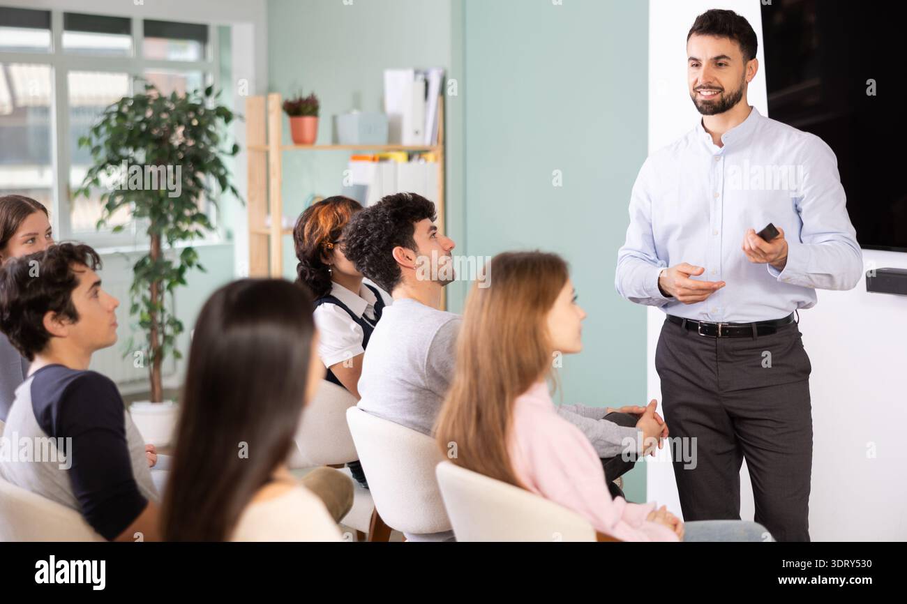 Male teacher explaining topic to students using digital board Stock Photo